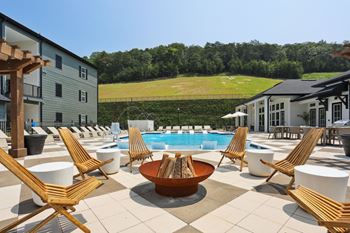 A large outdoor patio with a pool and chairs at Arcadia Cartersville Apartments, Georgia, 30121